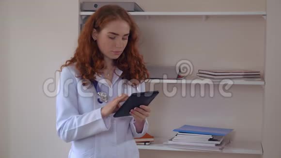 专业年轻治疗师手持触摸屏设备视频的预览图