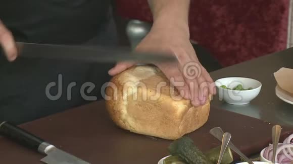 面包圈男手在桌子上切面包视频的预览图