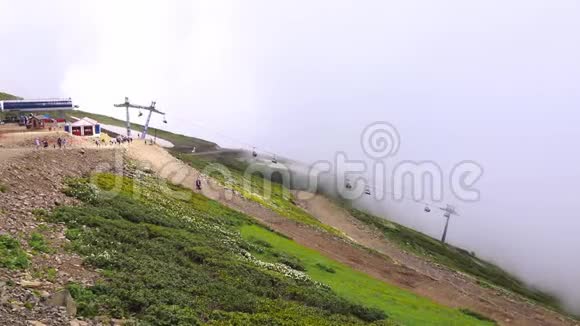 艾布拉岭缆车和小木屋穿过云层克拉斯纳亚罗萨库特滑雪场附近的山脉视频的预览图