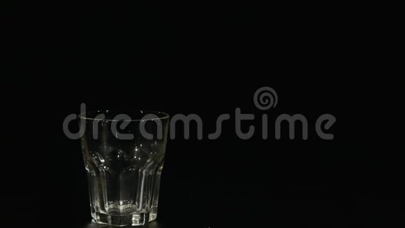 在黑色的背景下将长流的牛奶倒入玻璃杯中视频的预览图