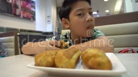 快乐的亚洲预科男孩享受早晨的早餐视频的预览图