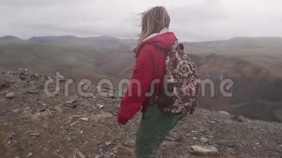 游客在倾盆大雨中走过山旅行女孩带背包视频的预览图