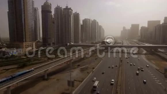 美丽的鸟瞰未来主义城市景观与道路汽车火车摩天大楼在日落阿联酋迪拜视频的预览图