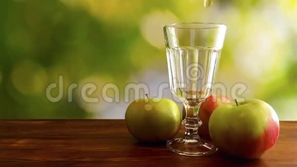 天然背景下苹果汁倒入玻璃中的慢动作视频视频的预览图