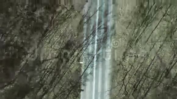 空中拍摄的汽车路在森林里的一个春天的一天俯视4K视频视频的预览图