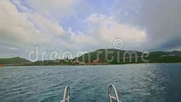 带着头轨的船在蔚蓝的大海上驶向绿色的岛屿视频的预览图