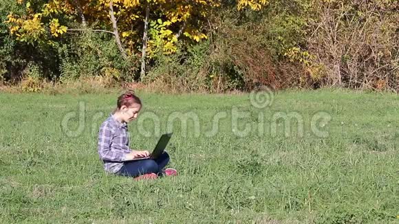 秋天公园里玩手提电脑的小女孩视频的预览图