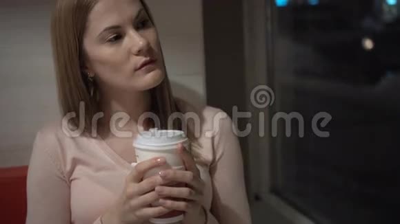 美丽迷人的年轻女子在咖啡馆喝咖啡在等朋友晚上好咖啡视频的预览图