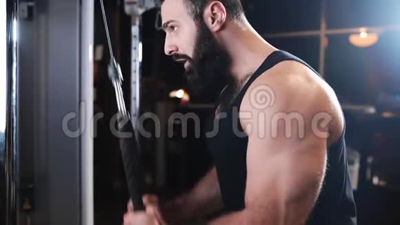 强壮的男人在健身房锻炼肌肉在模拟器上锻炼力量在健身俱乐部锻炼运动员白种人视频的预览图