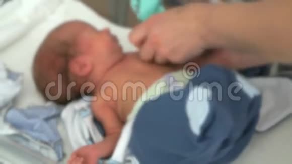 医护人员将新生儿抱在婴儿床上视频的预览图