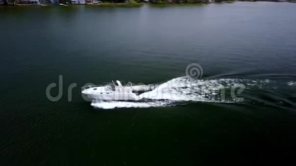 令人惊叹的4k空中无人机观景豪华白色摩托艇游艇在平静的深蓝河水中缓缓离去视频的预览图