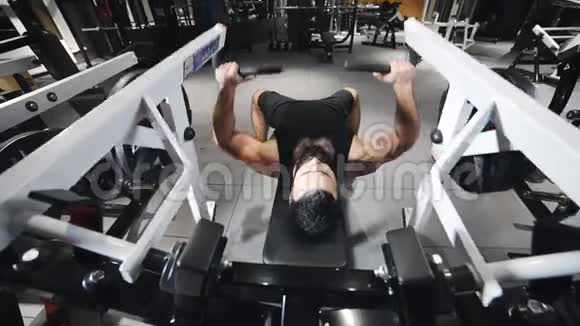 强壮的男人在健身房锻炼肌肉在模拟器上锻炼力量在健身俱乐部锻炼运动员白种人视频的预览图