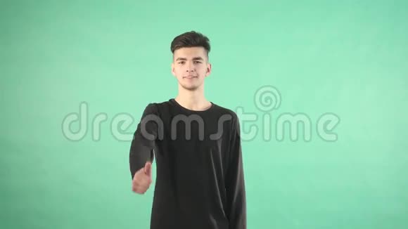 年轻男子微笑着竖起大拇指被孤立在绿色的背景上视频的预览图