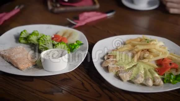 美味可口的菜肴有鱼鸡肉沙拉和酱汁餐厅的一张桌子开着两张一起吃饭视频的预览图