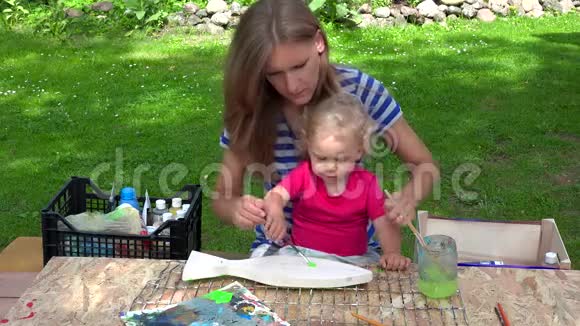 女子带着女儿画木鱼装饰视频的预览图