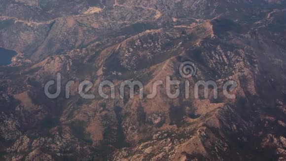 巨大的岩石山顶峰尖锯齿状悬崖边缘广射空中远处从喷气式飞机窗外眺望视频的预览图