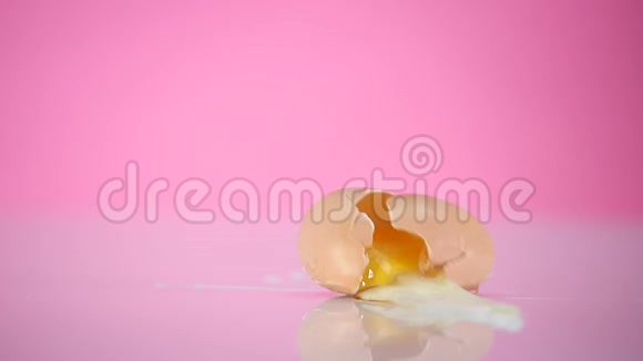 鸡蛋掉下来摔在粉红色的背景上视频的预览图