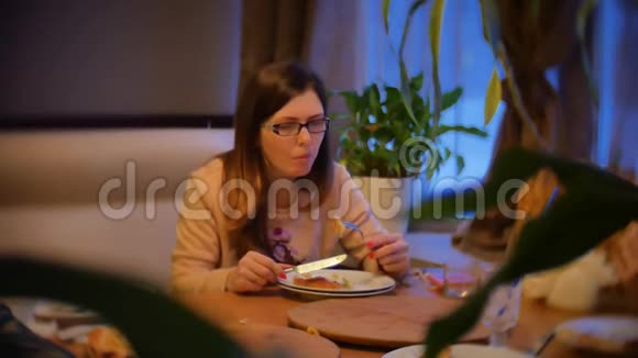女孩吃比萨饼坐在咖啡馆晚上晚餐室内快餐慢动作视频视频的预览图
