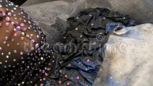 时尚设计师用闪闪发光的莱茵石闪闪发光的金属制成一个戴着黑色面具的模特外星人女孩的形象视频的预览图