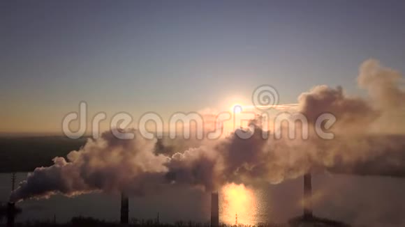 日落天空背景下工厂烟囱冒出的烟视频的预览图