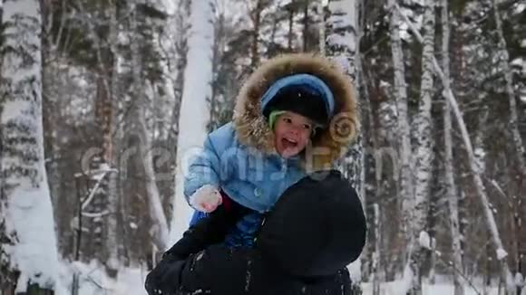 他在冬季公园和宝宝玩向上爬视频的预览图