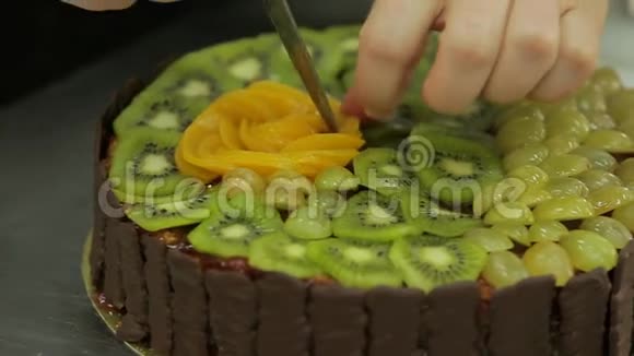 用猕猴桃装饰巧克力蛋糕把桃子摆成花朵的形状视频的预览图