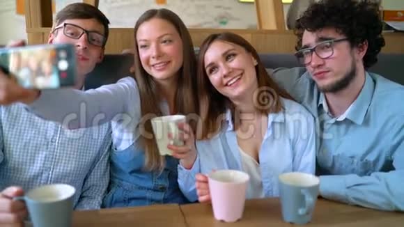 微笑的朋友坐在咖啡馆里有乐趣的交流和自拍慢动作视频的预览图