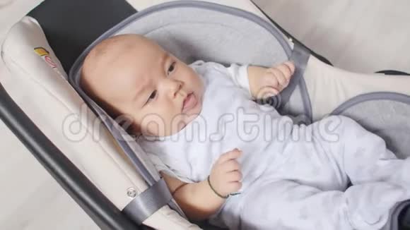 坐在汽车座椅上的新生男婴视频的预览图