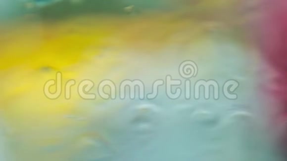背景滴和污渍在玻璃上彩色的黄绿色补丁在模糊的背景视频的预览图