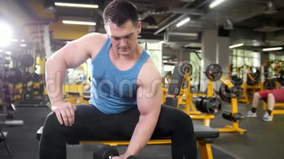 举重肌肉运动员用哑铃训练二头肌视频的预览图