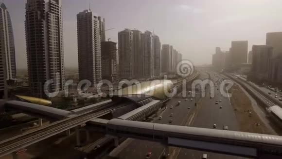 美丽的鸟瞰未来主义城市景观与道路汽车火车摩天大楼在日落阿联酋迪拜视频的预览图