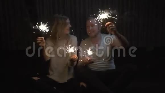 情侣男孩和女孩手里拿着火花玩得开心接吻慢动作视频的预览图