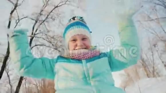 有趣的女孩骑在雪橇上做一个有趣的脸照相机安装在雪橇上视频的预览图