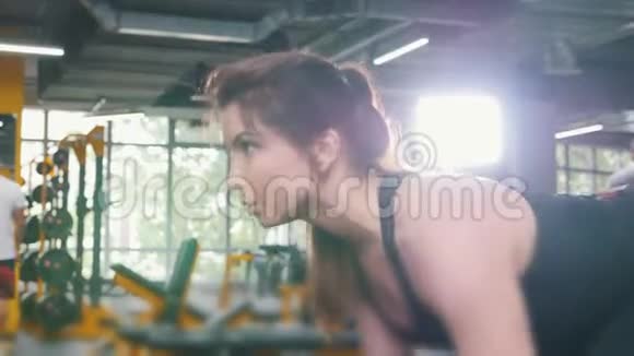 女子运动员在健身房举起哑铃关闭视频的预览图