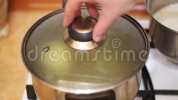 烧水壶中的洋葱是在家庭炉灶上准备的慢动作视频的预览图