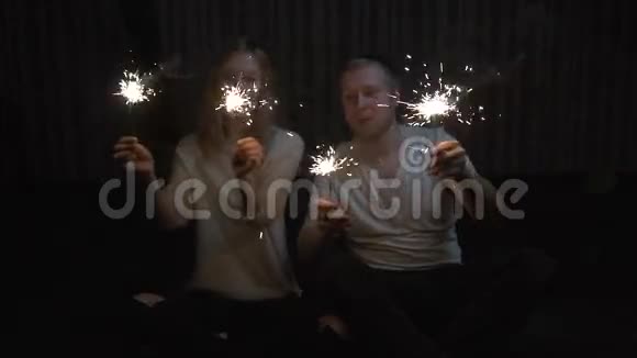 年轻的女孩和男人拿着火花和微笑慢动作视频的预览图