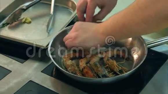 厨师男手把大虾放到煎锅上视频的预览图