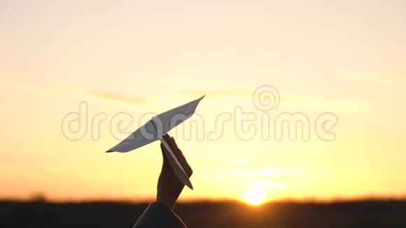 女人在日落的背景下发射纸飞机想去度假或旅行的概念视频的预览图