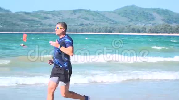 泰国普吉岛邦涛海滩上穿着跑鞋和短裤跑步的男子视频的预览图