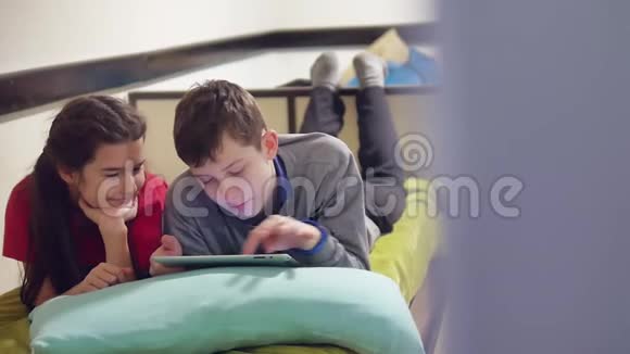 男孩和女孩在玩平板电脑兄妹儿童社交媒体在线游戏室内平板电脑视频的预览图