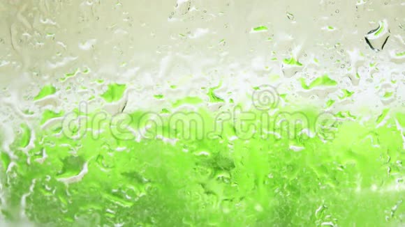 玻璃上的水滴和白色背景下的绿色苹果离焦4K镜头视频的预览图
