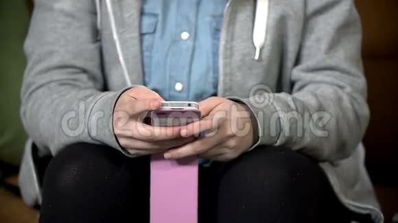年轻女孩在她的智能手机上输入一些文字视频的预览图