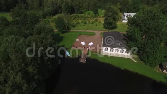 漂亮的婚礼装饰空中无人机在公园里用池塘和宫殿建筑射击乡间视频的预览图