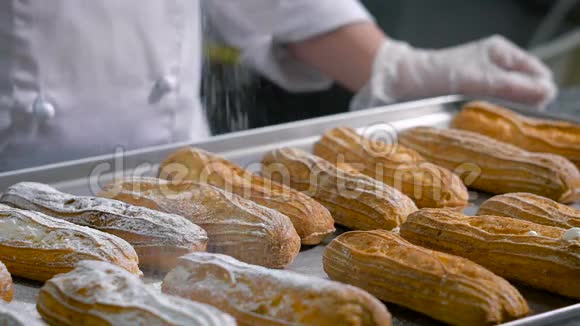 糕点厨师穿着白色厨师服透明手套从一个特殊的杯子里撒上糖粉一个视频的预览图