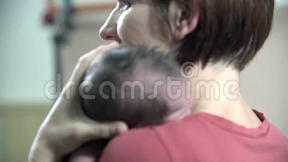 妈妈抱着她的孩子挨着她的肩膀视频的预览图