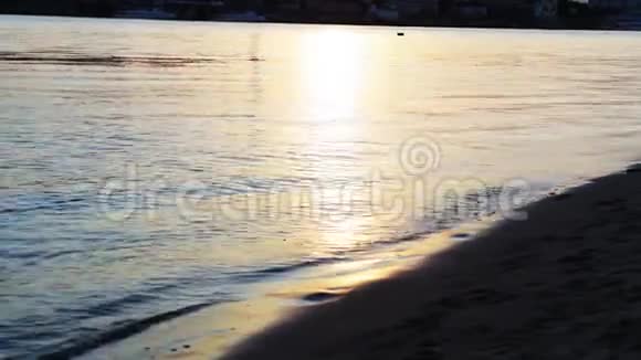 日落时的女孩赤脚沿着海岸散步女孩赤脚在水上行走视频的预览图