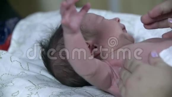 一个小婴儿的近镜头让他的手臂绕着视频的预览图