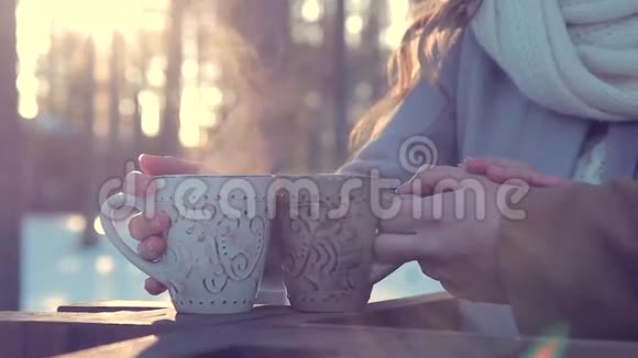 冬天男人和女人在室外用杯子捧着热茶视频的预览图