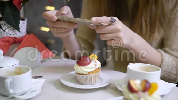 女人的手她的咖啡坐在社交网络的咖啡馆里拍照咖啡店的桌子上有视频的预览图