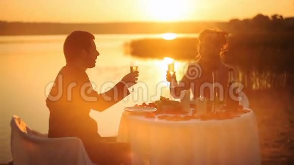 年轻夫妇在海滩上共享浪漫晚餐视频的预览图
